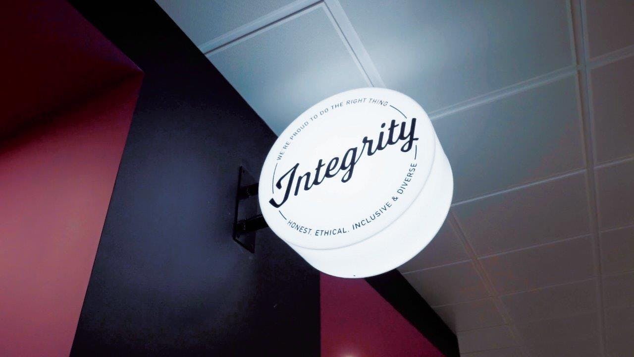 a lit sign in our MK office showing the word 'integrity', one of our Aiimi values